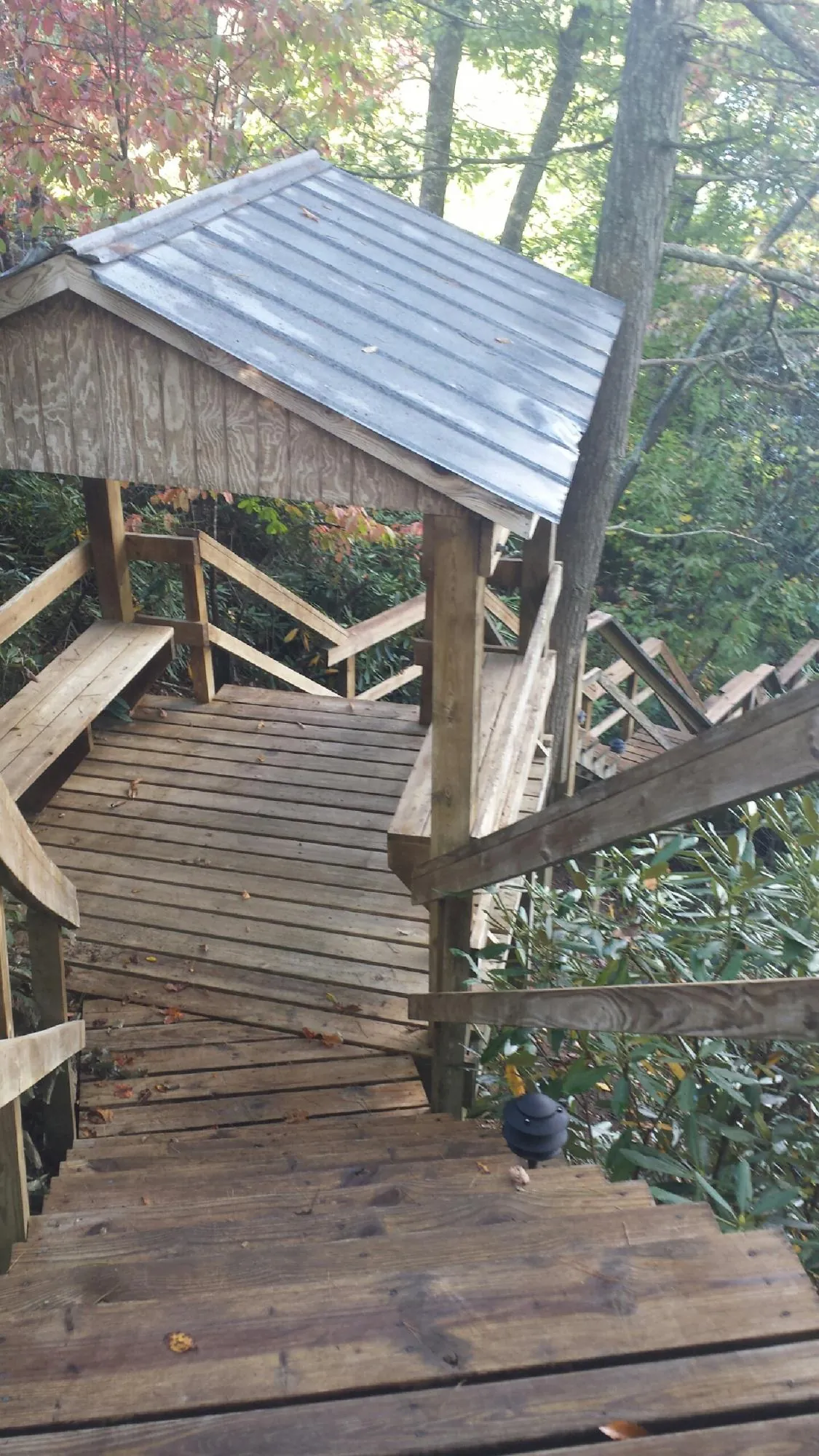 Metal roofed shelter over wooden steps on a wooded walkway — Skylight Repair & Installation work by our crew in Hall